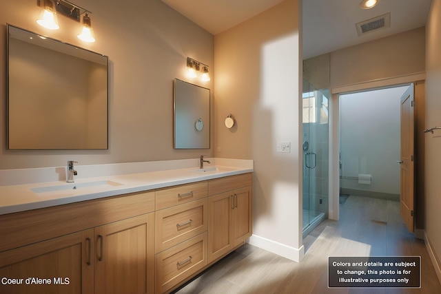 bathroom with a shower stall, double vanity, visible vents, and a sink