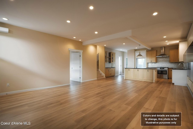 kitchen featuring stainless steel range, dark countertops, open floor plan, wall chimney exhaust hood, and decorative backsplash