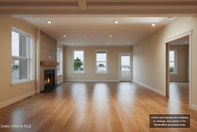 unfurnished living room with light wood finished floors, recessed lighting, a fireplace, and baseboards