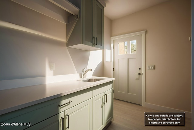 kitchen featuring a sink, light wood-type flooring, baseboards, and light countertops