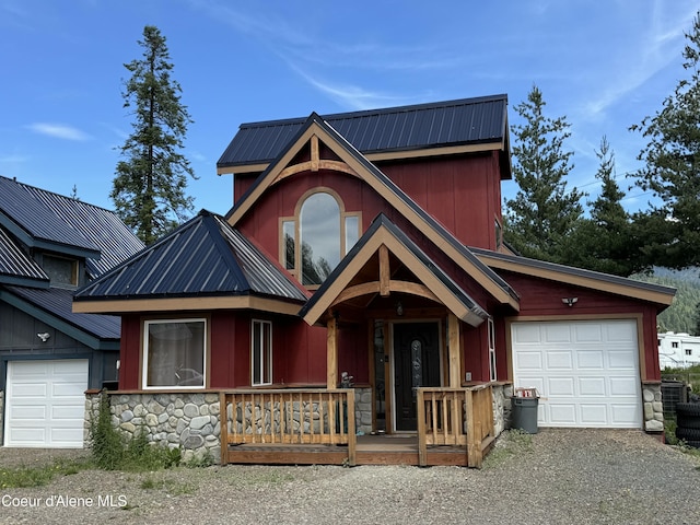 view of front of house with an attached garage, a porch, metal roof, and stone siding