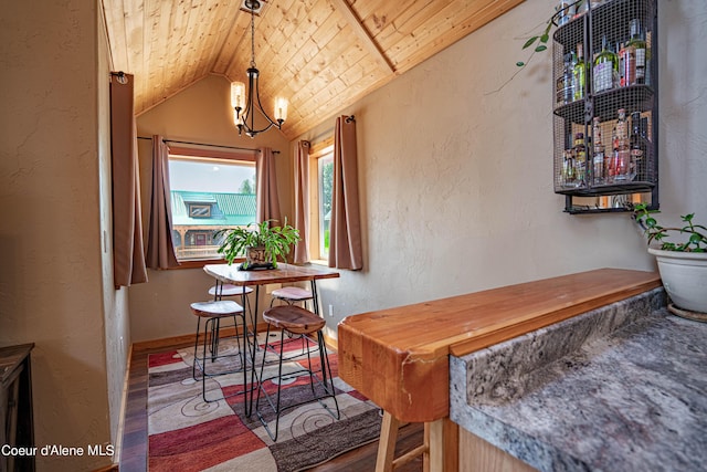 dining space featuring wood ceiling, vaulted ceiling, wood finished floors, a notable chandelier, and a textured wall