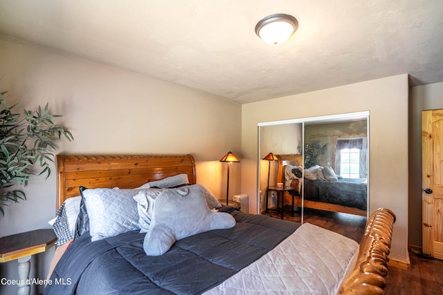 bedroom with wood finished floors and a closet