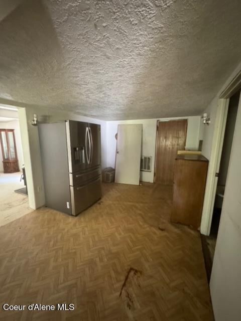 interior space featuring parquet flooring and a textured ceiling