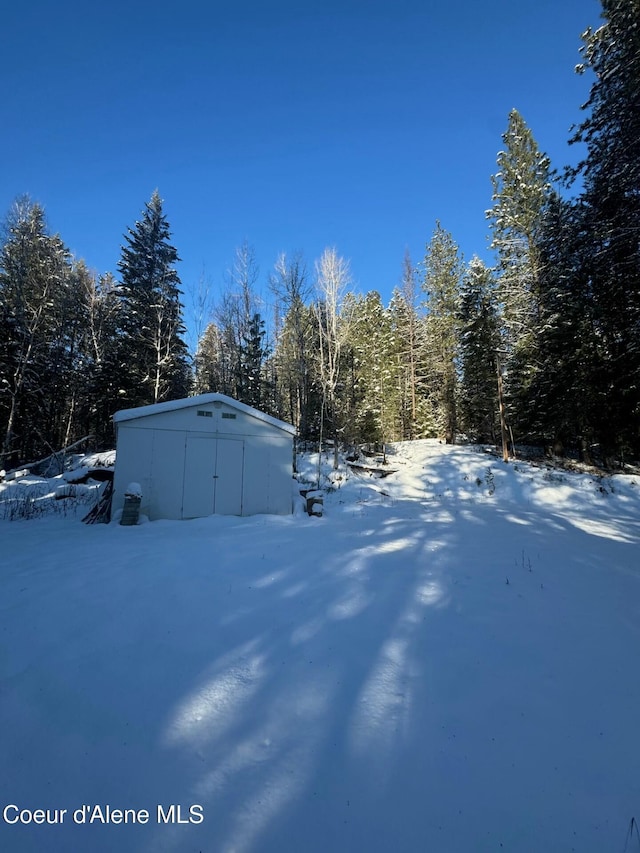 yard layered in snow with an outdoor structure