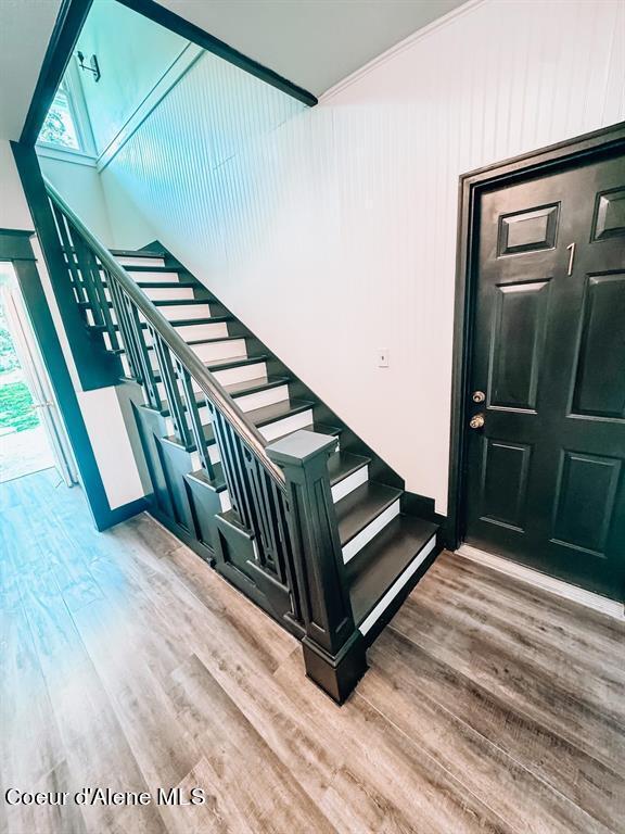 stairway featuring hardwood / wood-style flooring and a healthy amount of sunlight