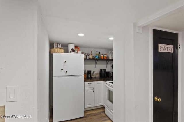 kitchen featuring white cabinetry, dark hardwood / wood-style floors, and white appliances