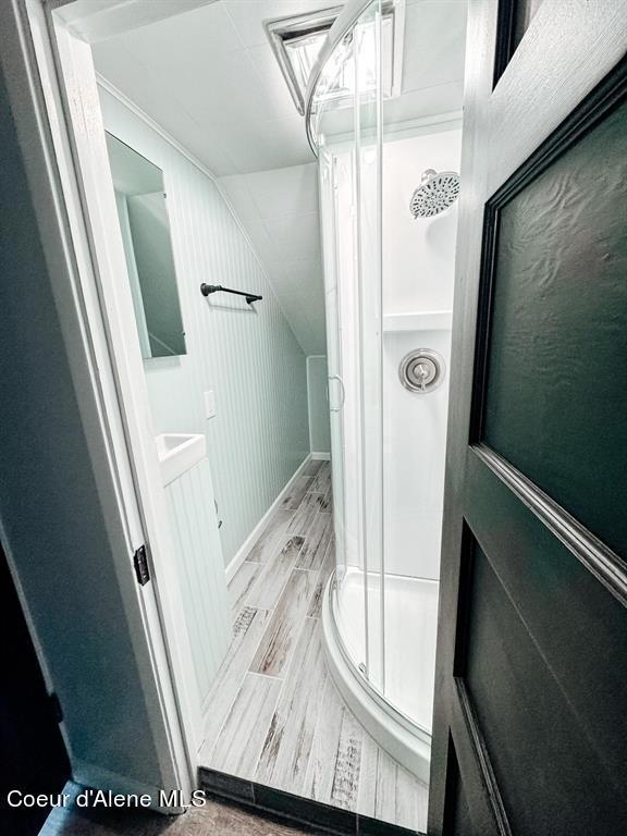 bathroom with hardwood / wood-style floors and an enclosed shower