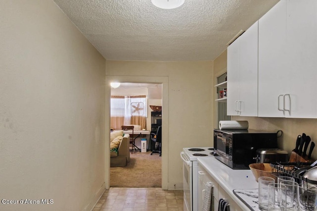 kitchen featuring white cabinetry, a textured ceiling, and electric stove