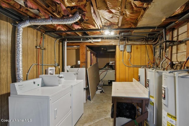 basement featuring wooden walls, electric water heater, and washing machine and dryer