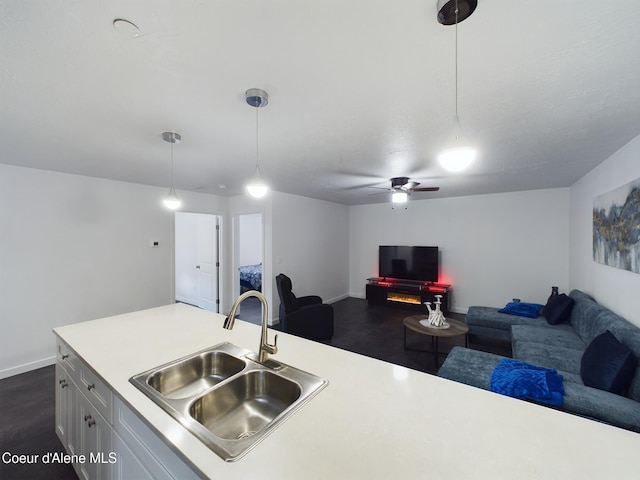 kitchen featuring dark hardwood / wood-style floors, ceiling fan, sink, and hanging light fixtures