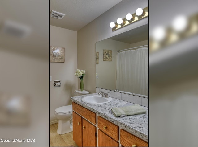 bathroom featuring vanity, hardwood / wood-style floors, and toilet