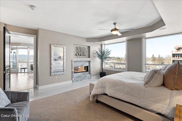 bedroom with a premium fireplace and ceiling fan