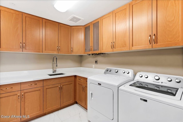 clothes washing area featuring sink, cabinets, and independent washer and dryer