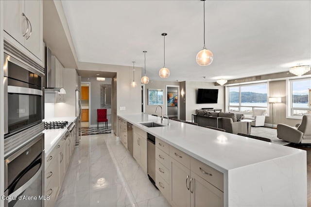 kitchen with a spacious island, white cabinetry, appliances with stainless steel finishes, and sink