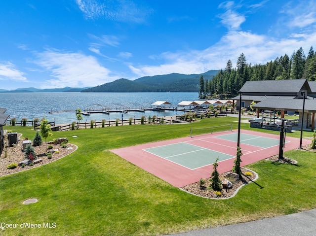 view of basketball court with a water and mountain view and a yard