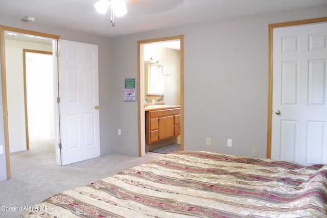 carpeted bedroom with connected bathroom, sink, and ceiling fan