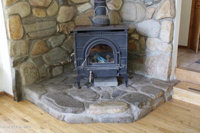 room details with a wood stove and hardwood / wood-style floors