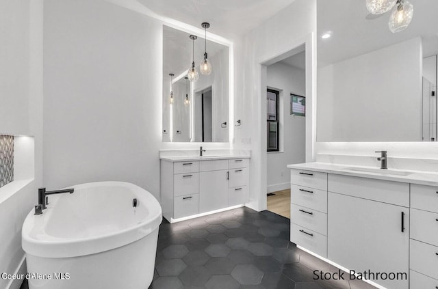 bathroom featuring tile patterned floors, a bathtub, and vanity