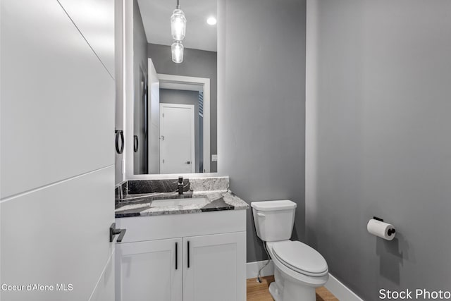 bathroom featuring vanity, toilet, and baseboards