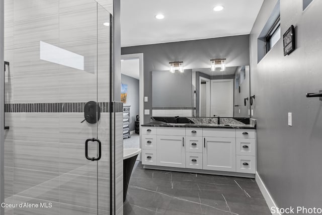 bathroom with baseboards, a freestanding bath, vanity, a shower stall, and recessed lighting