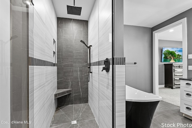 full bathroom with a stall shower, a soaking tub, and tile patterned flooring