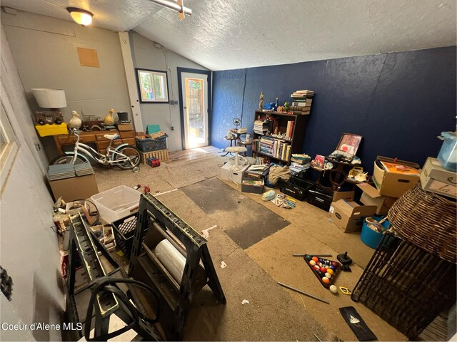 interior space with vaulted ceiling and a textured ceiling