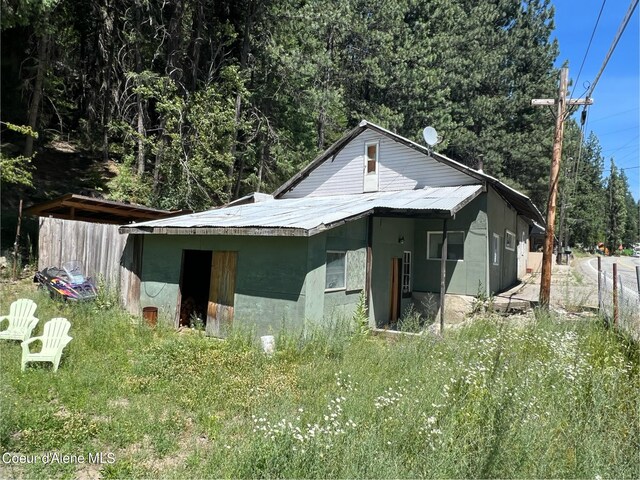 exterior space featuring metal roof and a view of trees