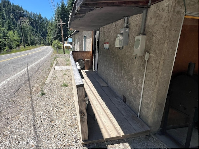 exterior space featuring a forest view and stucco siding