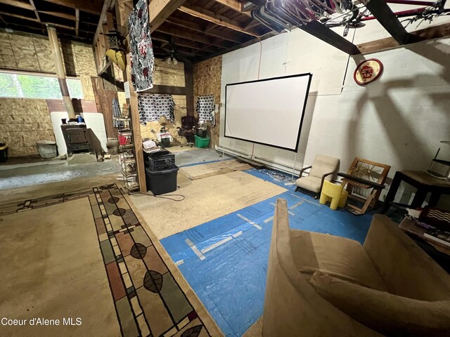 home theater room with a wood stove and concrete floors