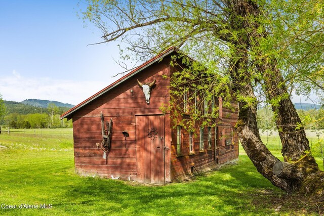 view of outbuilding featuring a yard and a mountain view