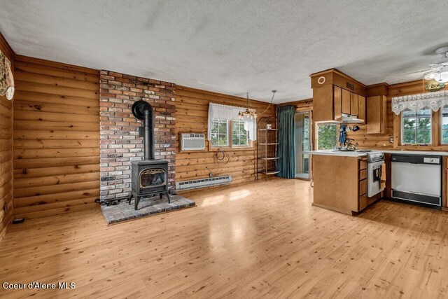 kitchen featuring a wood stove, rustic walls, a baseboard heating unit, white dishwasher, and light hardwood / wood-style floors