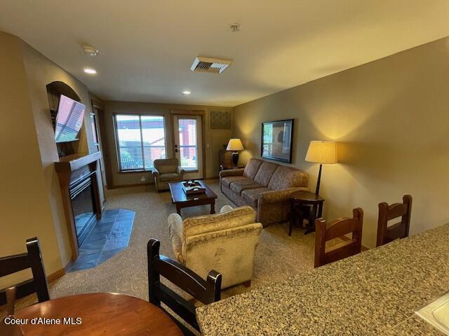 carpeted living room with a tiled fireplace