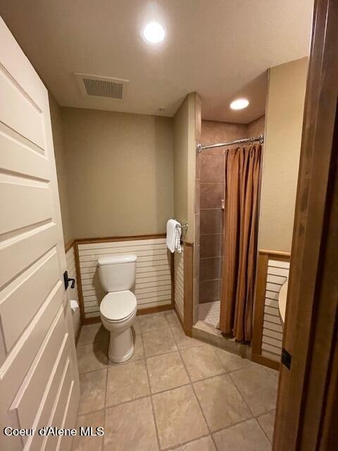 bathroom featuring tile patterned flooring, a shower with shower curtain, and toilet