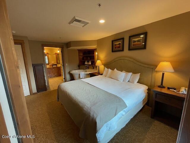 bedroom featuring connected bathroom and carpet floors