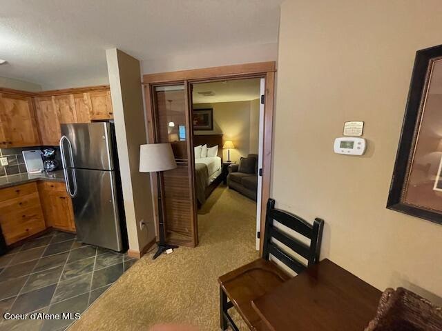 kitchen with dark carpet, tasteful backsplash, tile counters, and stainless steel fridge