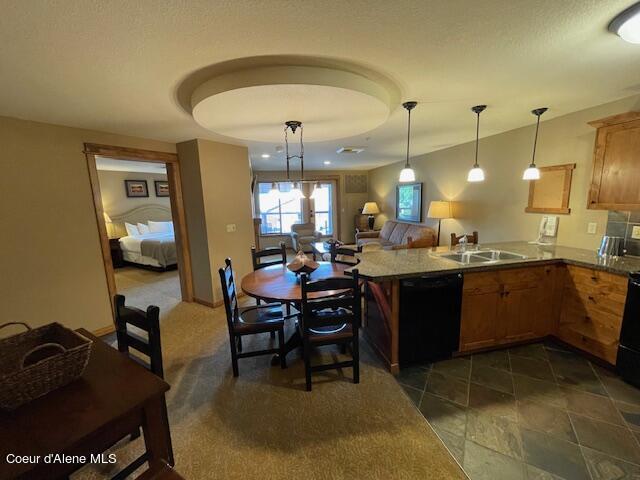 110 Morning Star Dr Unit 237, Kellogg, ID 83837 - kitchen featuring a sink, dishwasher, brown cabinetry, a peninsula, and pendant lighting