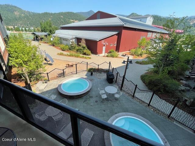 exterior space featuring a mountain view, a patio area, and a pool with hot tub