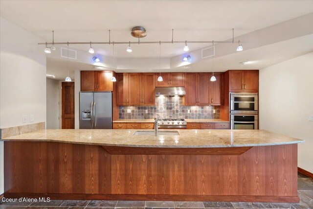 kitchen with dark tile patterned floors, light stone countertops, appliances with stainless steel finishes, decorative backsplash, and sink