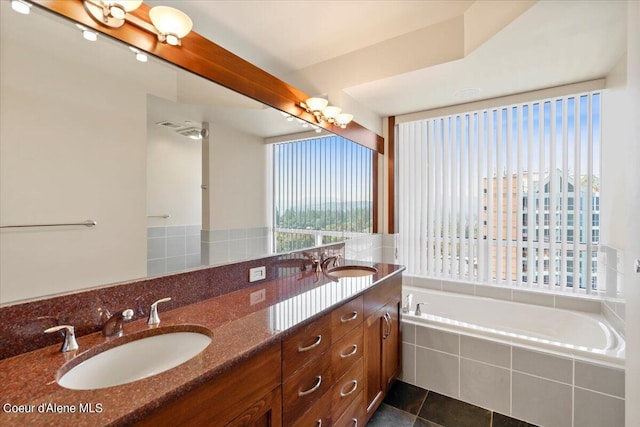 bathroom featuring double vanity, tile patterned flooring, a sink, and a bath