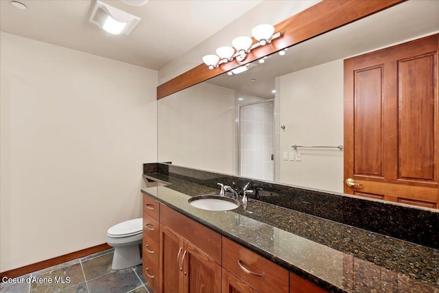 bathroom featuring toilet, a stall shower, stone finish flooring, and vanity