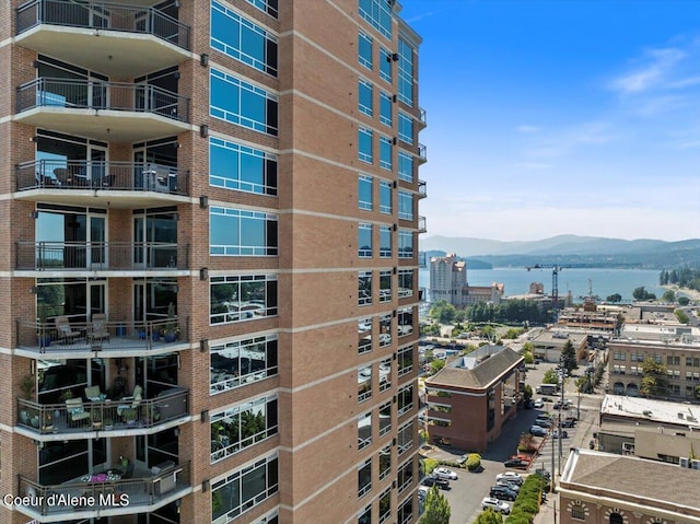 view of building exterior featuring a view of city and a water and mountain view