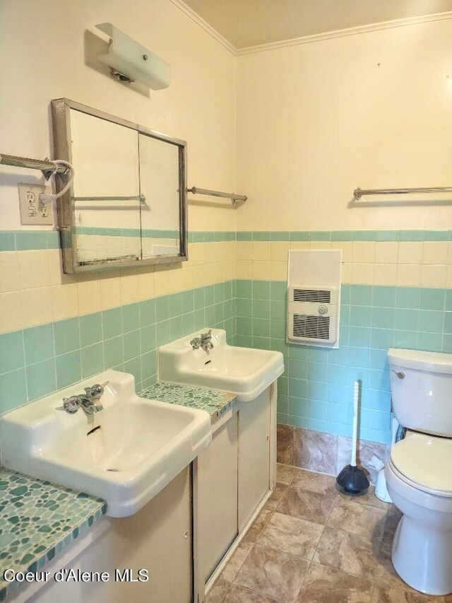 bathroom with crown molding, heating unit, tile walls, and toilet