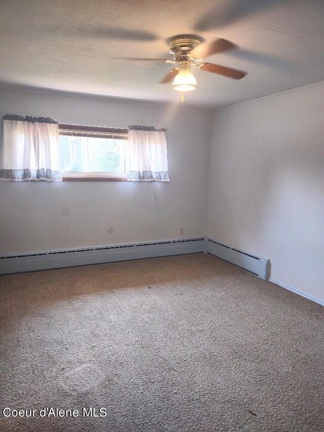 carpeted spare room featuring ceiling fan and baseboard heating