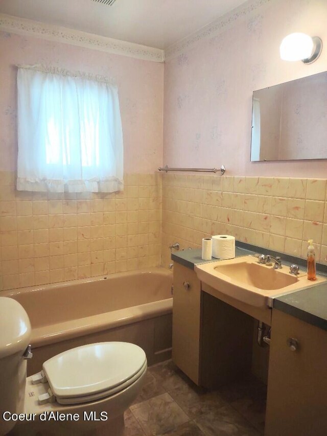 bathroom with toilet, tile walls, and a washtub