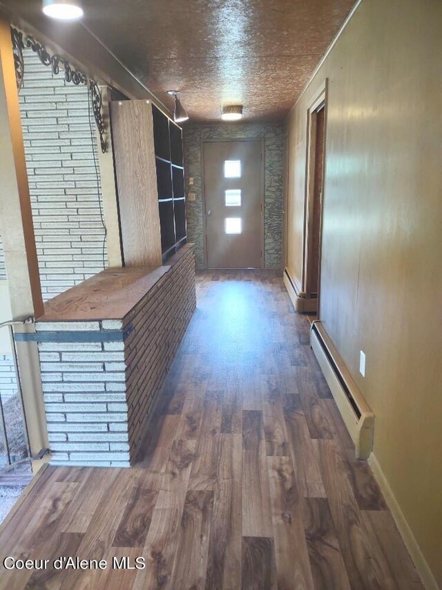 hallway with a baseboard radiator and dark wood-type flooring