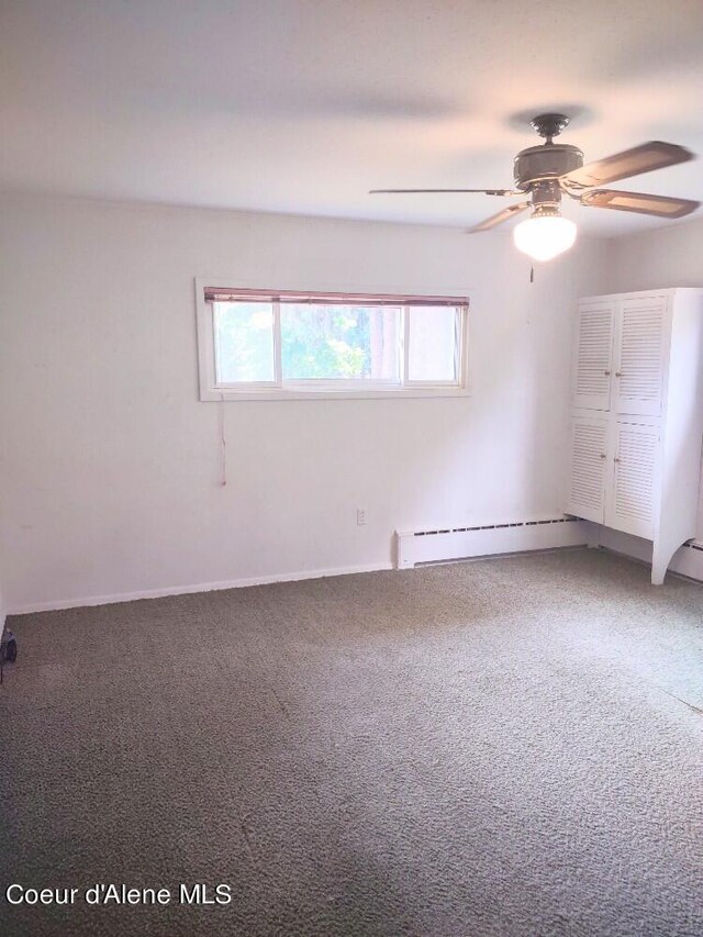 unfurnished room with ceiling fan, carpet flooring, and a baseboard radiator