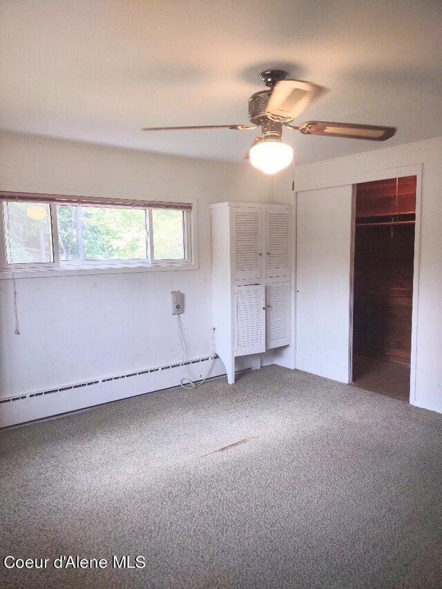 unfurnished bedroom with ceiling fan, carpet floors, and a baseboard heating unit