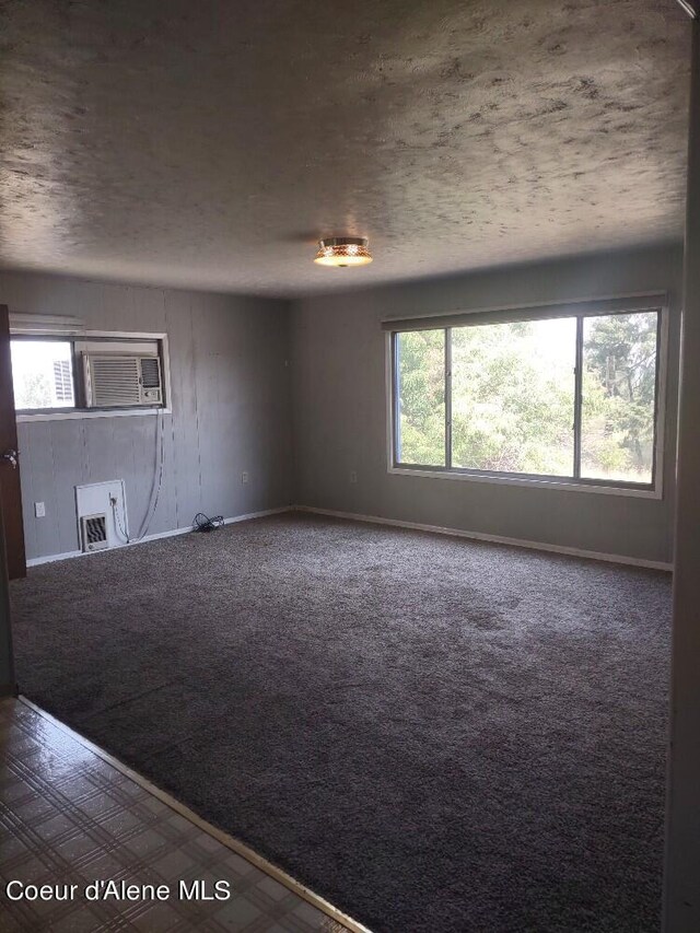 empty room featuring carpet and an AC wall unit