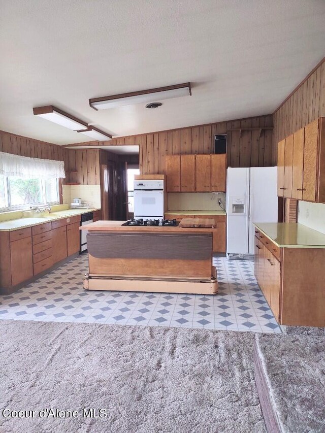 kitchen featuring white appliances and wooden walls